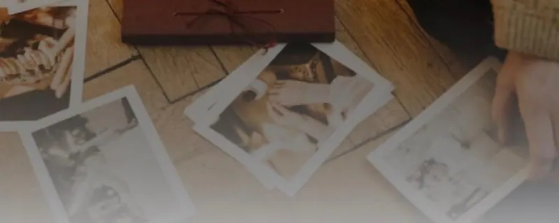 Foto's liggen uitgespreid op een houten vloer rond een fotoalbum, voor de workshop fotolezen in de energie