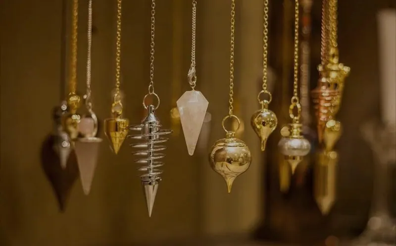 Verschillende pendels van kristal en metaal aan kettingen